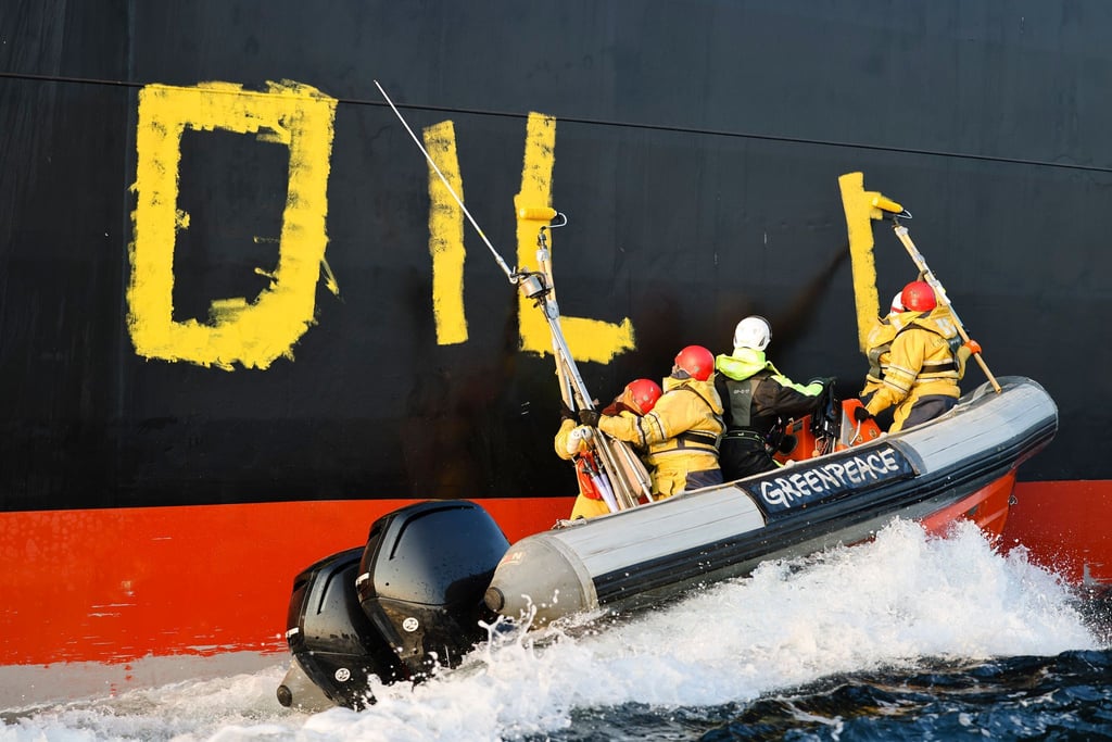 Aktivisten der Umweltorganisation Greenpeace malen den Schriftzug „Oil fuels war“ auf den Rumpf eines Schiffes, das russisches Öl auf der Ostsee transportiert. (Archivbild)