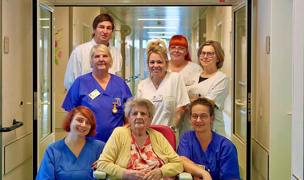 Knochenbruch in nur zwei Wochen erfolgreich behandelt: Das interdisziplinäre Behandlungsteam in Dessau und die 102-Jährige Patientin am Tag ihrer Entlassung.