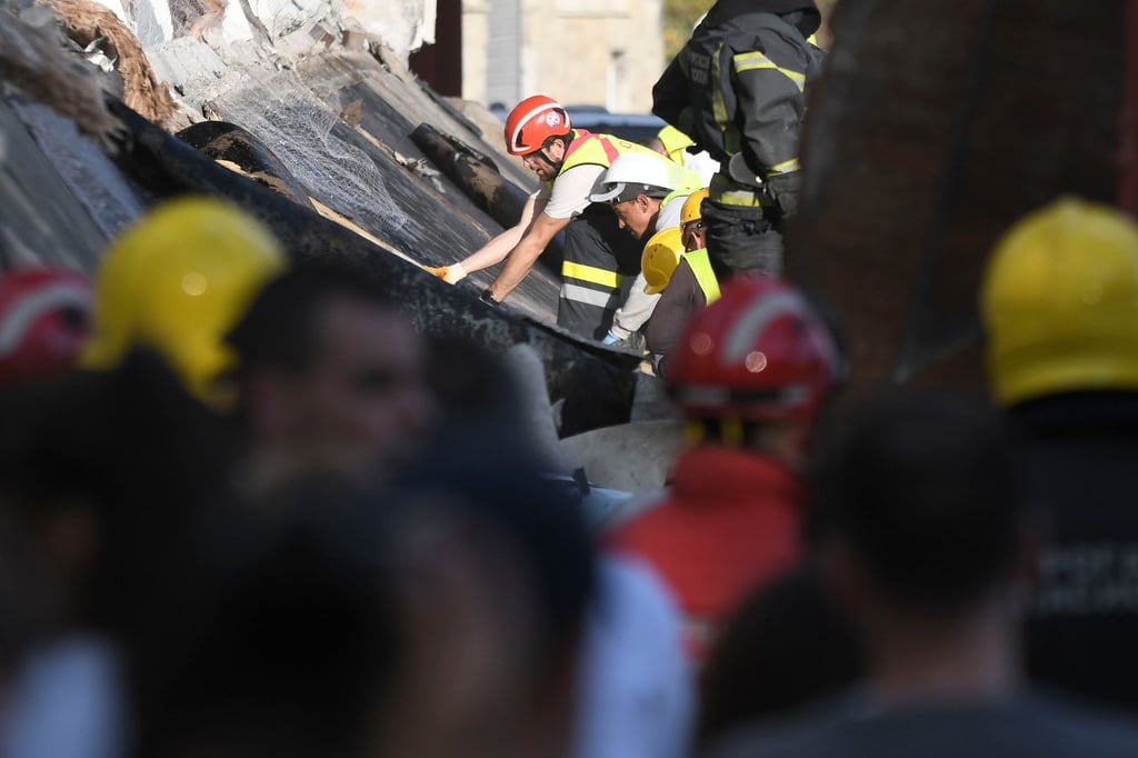 Rettungsmannschaften suchen unter dem eingestürzten Bahnhofsvordach in Novi Sad nach Überlebenden.