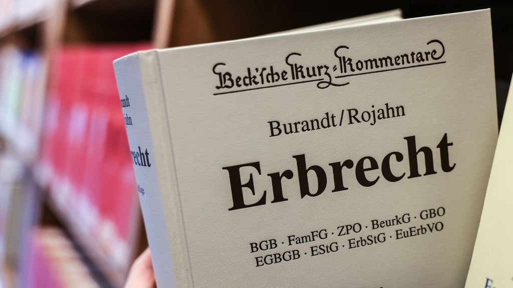 Eine Juristin nimmt den Gesetzestext Erbrecht aus dem Regal.&nbsp;