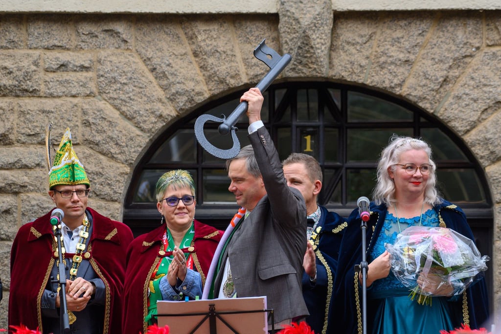 In Sachsen-Anhalt sind die Narren los: Steffen Amme (Mitte), Oberbürgermeister der Stadt Aschersleben, steht vor dem Rathaus mit einem übergroßen Schlüssel in der Hand.