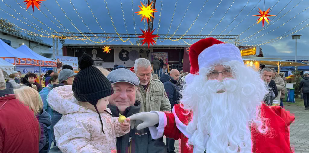 Unter einer riesigen Lichterdecke überraschte der Weihnachtsmann auf dem Adventsmarkt in Tangerhütte viele Kinder. Auch Tilda (1) auf dem Arm von Opa Burkhard Klimt bekam etwas Süßes.