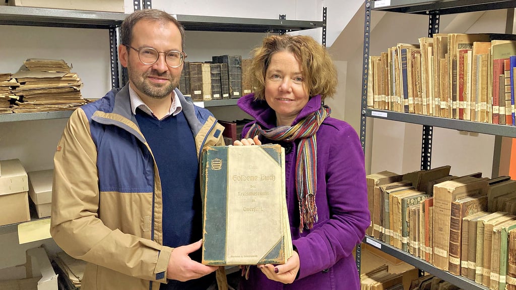 Provenienzforscherin Anastasia Yurchenko und Museologe Jan Stenzel zeigen auf Burg Querfurt das Goldene Buch des Kreismuseums