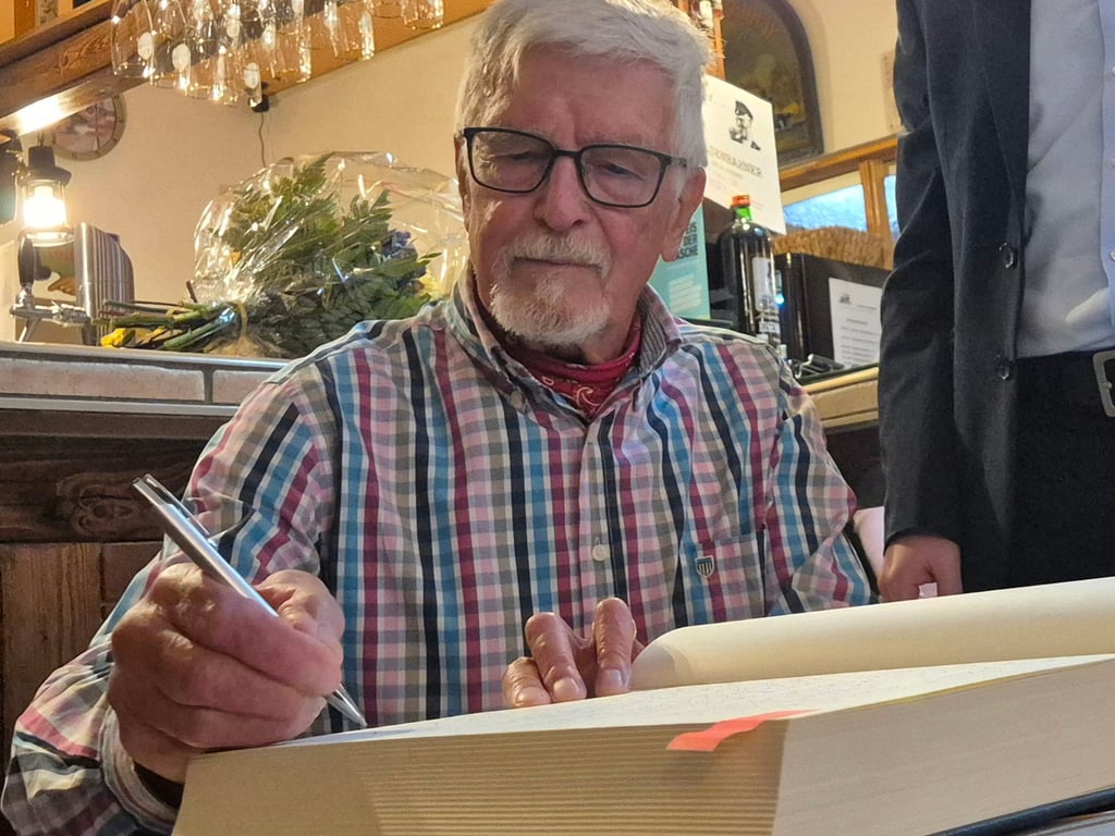 Wurde für sein Engagement geehrt: Wolfdieter Ludwig aus Harzgerode trägt sich ins Goldene Buch der Stadt ein.