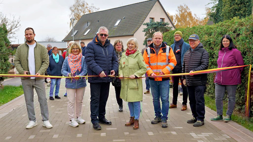 Zum symbolischen Scherenschnitt kamen unter anderem Stadtratsvorsitzender Felix Zietmann (v.l.), Anwohnerin Christel Augustin, Ortsbürgermeister Guido Kratzenberg, Rathaus-Bauverantwortliche Simone Heiß, Bürgermeisterin Marlies Cassuhn sowie Vertreter der Baufirma Buchheister.