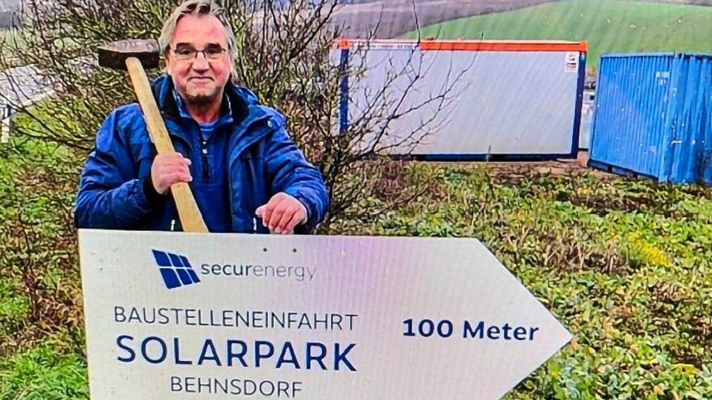 Projektentwickler Axel Czoski schlägt symbolisch das Hinweisschild auf die Baustelle für den Solarpark bei Behnsdorf ein.