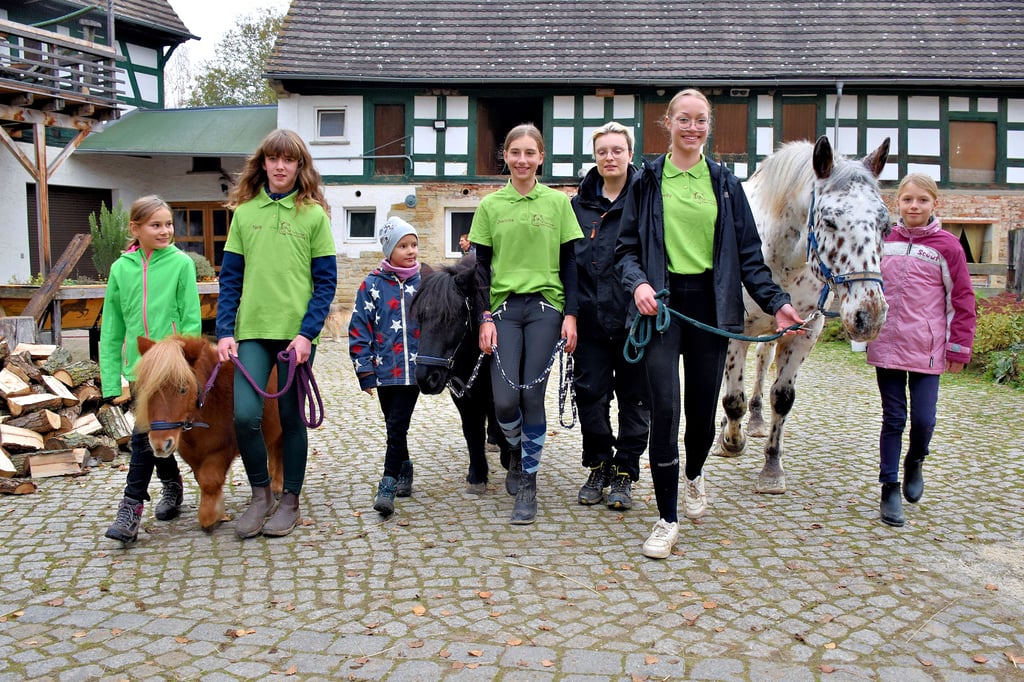 Luise, Nele, Palina, Charlotte, Anna-Luis, Emily und Greta (v.li.) führen die Ponys Lisa, Hanna und und den Knabstrupperwallach Plet über den Hof.