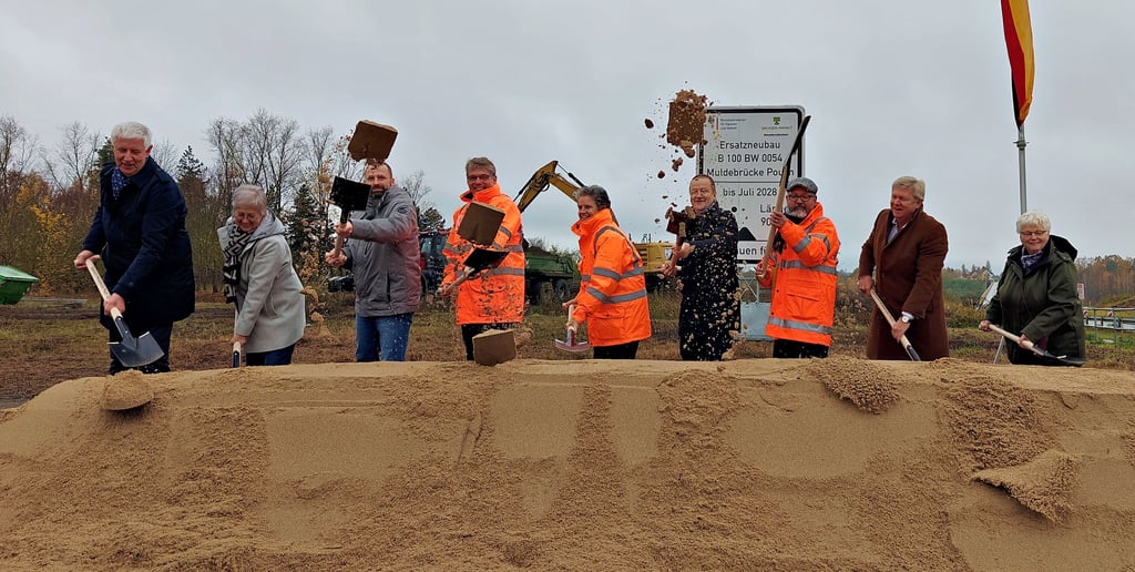 Hoch in die Luft fliegt der Sand beim gemeinsamen ersten Spatenstich für die neue Brücke von Landtagsmitglied Olaf Feuerborn, Muldestausees Ex-Bürgermeisterin Petra Döring, Bürgermeister Ferid Giebler, LSBB- Präsident Stefan Hörold, Ministerin Lydia Hüskens, Gero Marzahn vom Bundesverkehrsministerium, LSBB-Leiter Oliver Grafe, Kreistagschef Veit Wolpert und Pouchs Ortsbürgermeisterin Iris Hamella (v.l.).