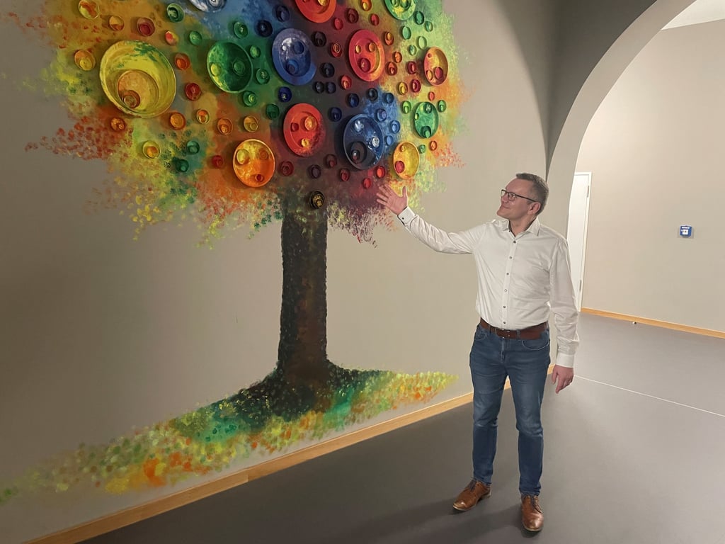 Thomas Seiler fühlt sich in der Weißenfelser Neustadtschule wohl. Er schaut stolz auf die von Schülern gestaltete Wand.