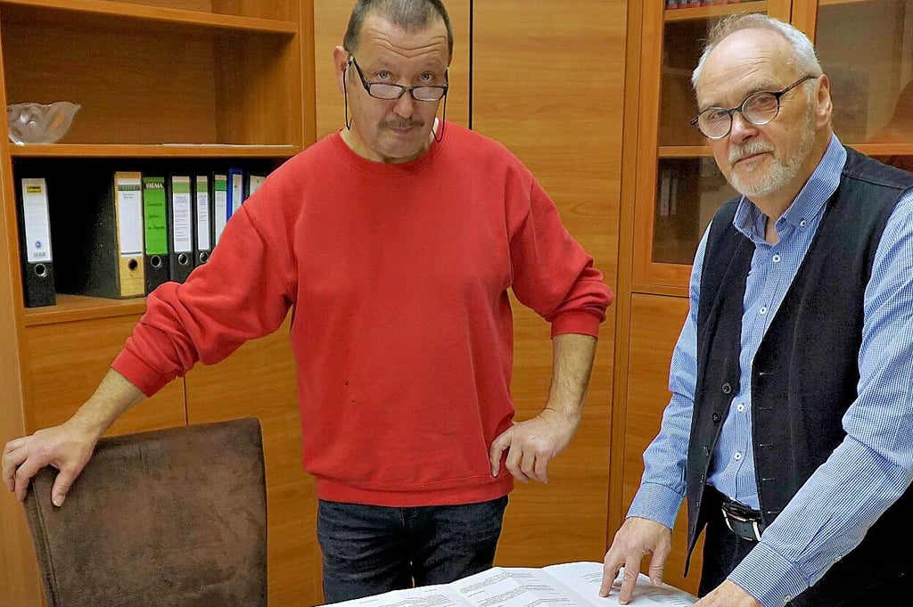 Döllnitz' Ortsbürgermeister Udo Arno Schmidt (re.) und Uwe Dannowski zeigen auf dem Plan auf das betreffende Grundstück.