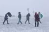 Frostige Temperaturen und leichter Schneefall haben den Brockengipfel in eine Winterlandschaft verwandelt - Wind macht auch diesen Harz-Wanderern zu schaffen. 