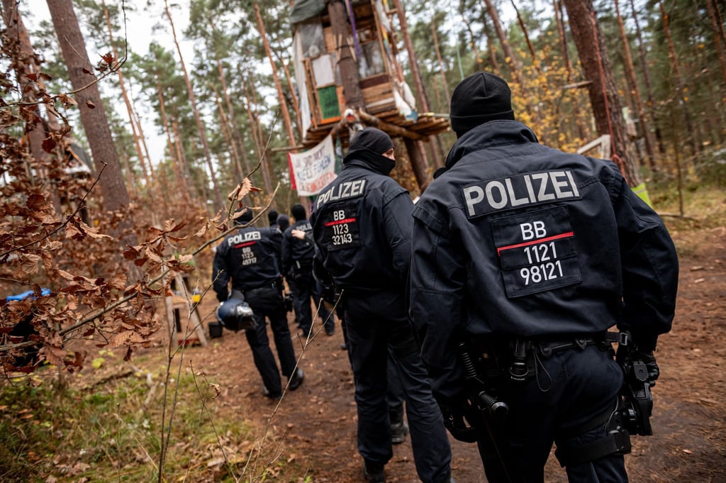 Polizeikräfte sperren ein Waldgebiet, in dem das Tesla-Protestcamp in Grünheide bei Berlin liegt.
