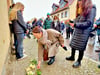 Angehörige der NS-Widerstandskämpfer Bruno Hinz und Marianne Latoschinski legen an den  im Fußweg vor dem Haus Korngasse 7 eingelassenen Stolpersteinen Rosen nieder.