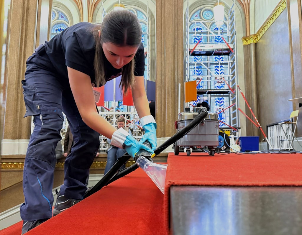 Elena Stamatiou (20) aus Hessen reinigt den roten Teppich im Treppenbereich des Roten Rathauses.