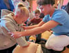 Marvin Arnold (r.) aus dem dritten Ausbildungsjahr zeigt den Kindern unter anderem, dass man bei der Herzdruckmassage die Arme ordentlich durchdrücken muss. 