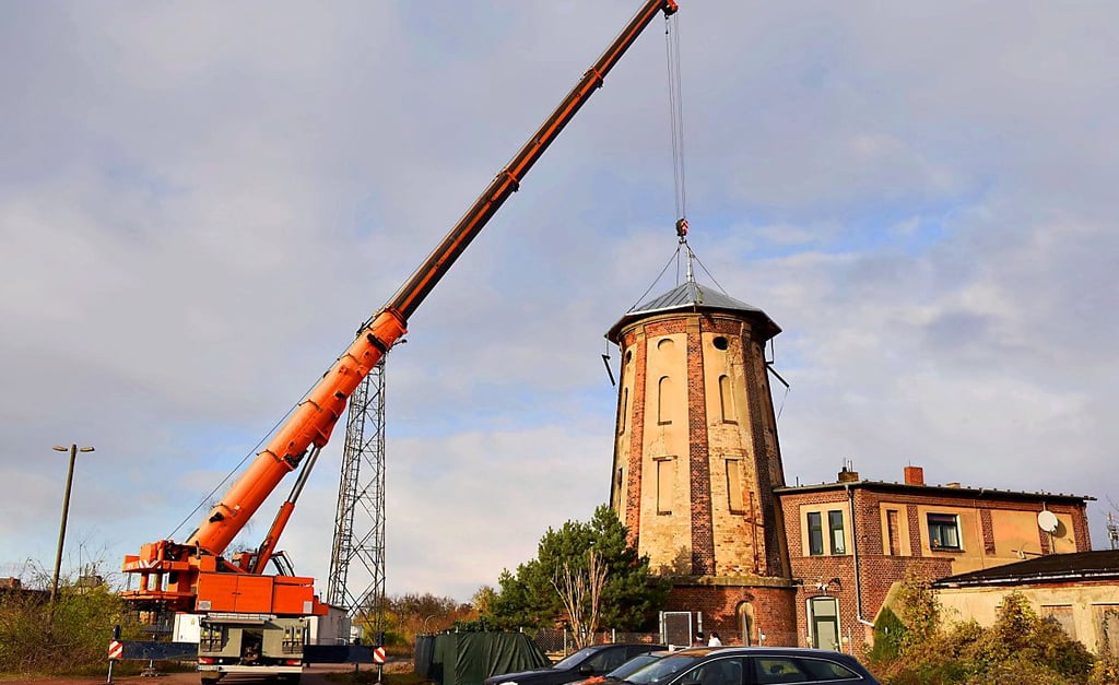 Per Riesenkran wurde das neue Dach auf den Wasserturm aufgesetzt.