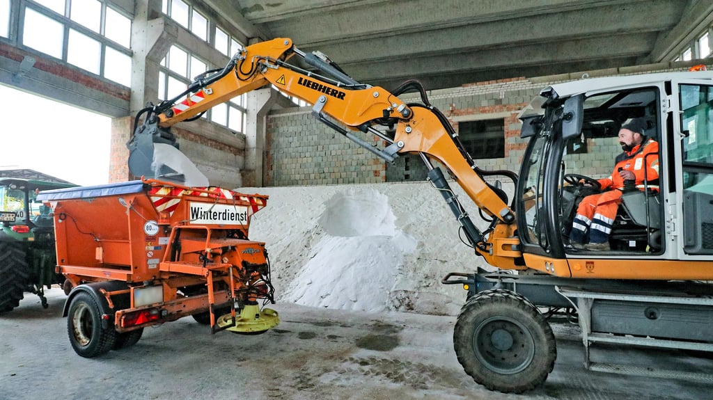Im Jessener Bauhof werden am Donnerstagnachmittag die Winterdienstfahrzeuge der Stadt mit Salz beladen, damit sie am Freitag zum Einsatz rollen können. Nils Busse befüllt hier in der Salzlagerhalle einen Streuanhänger an einem Traktor, der im Ostteil der Stadt auf Straßen unterwegs sein wird.