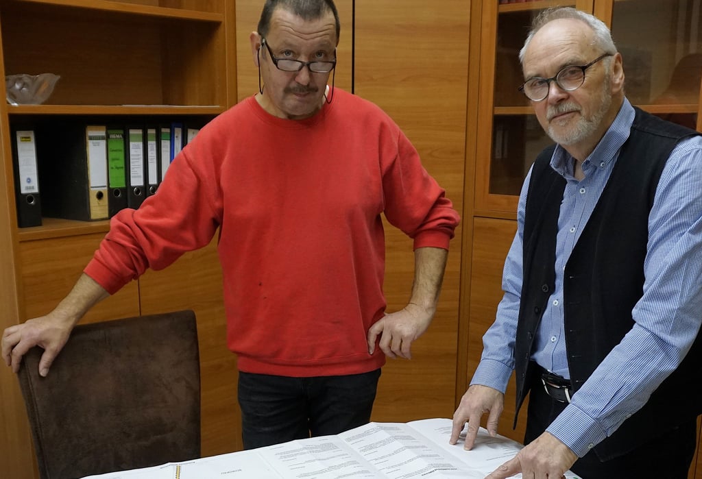 Döllnitz' Ortsbürgermeister Udo Arno Schmidt und Feuerwehr-Experte Uwe Danowski zeigen auf dem Plan auf das Grundstück, das mit dem Doppel-Gerätehaus bebaut werden soll.