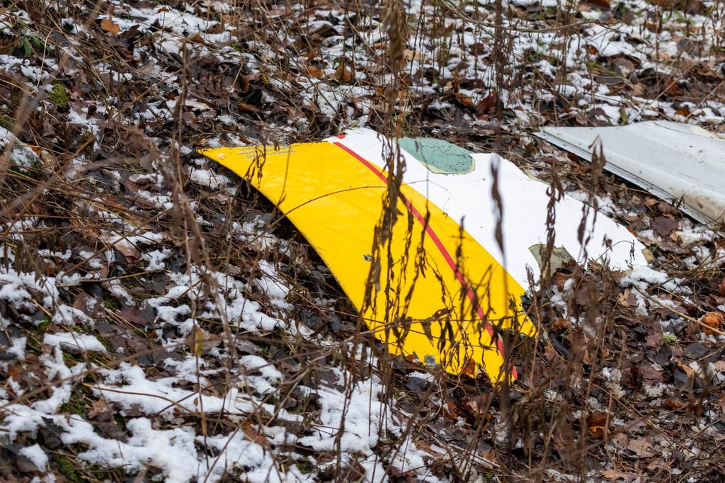 Auf einem Trümmerteil des abgestürzten Flugzeugs sind die DHL-Farben zu sehen.