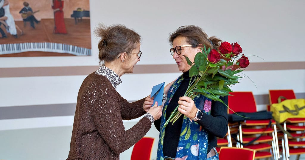 Zur Verabschiedung gibt es für Mechthild Andersch (r.) von den Kollegen ein Überraschungskonzert, zahlreiche Umarmungen und Rosen mit einem Umschlag.