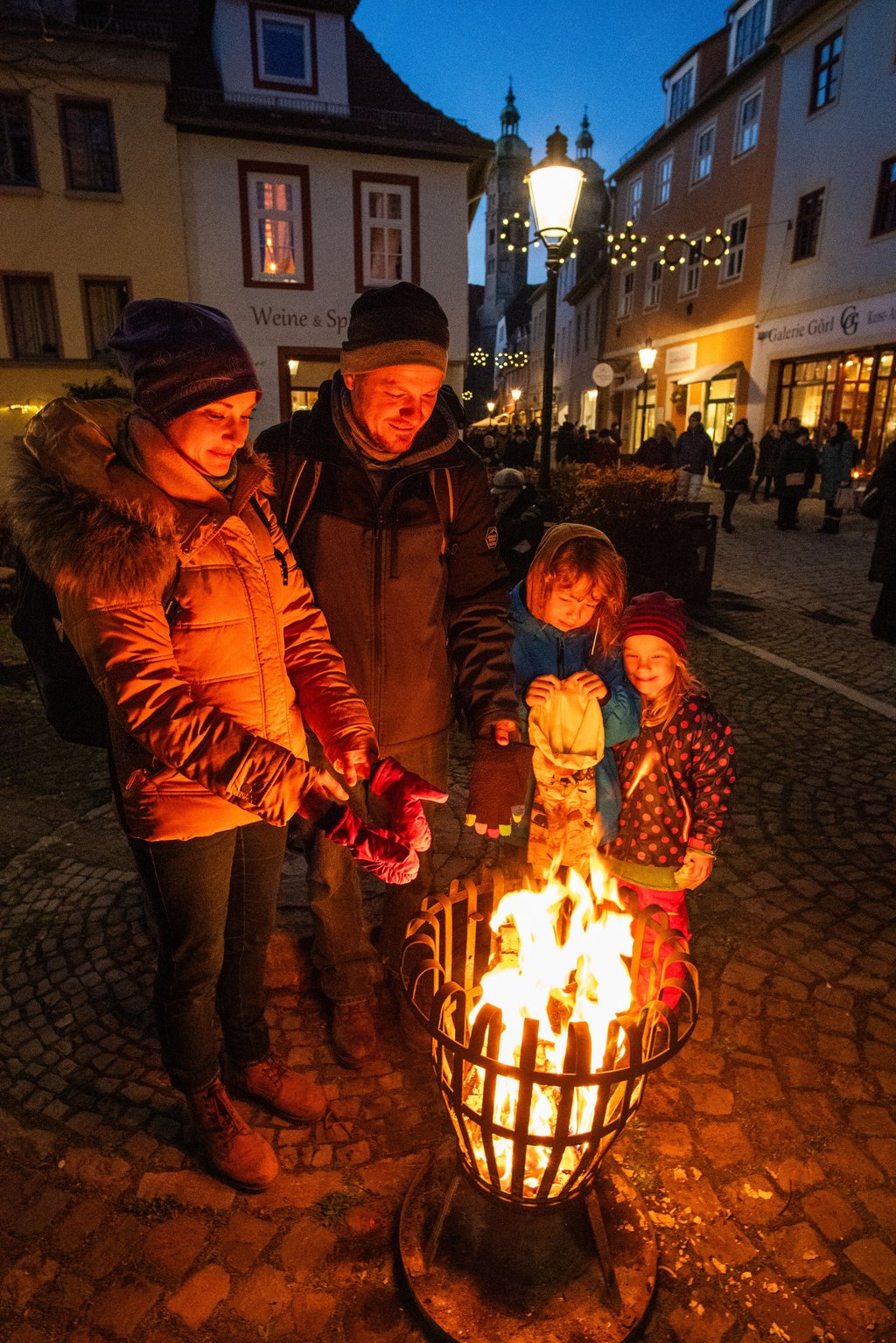 Familie Seidel aus Naumburg wärmt sich an der Feuerschale der "Zufriedenheit" am Steinweg.