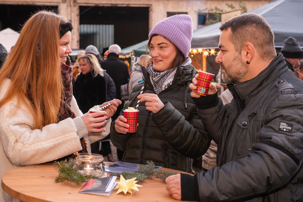 Leonie und Sophia Zirm sowie Tobias Krämer genießen im "Weinqaurtier" Eierpunsch und Glühapfel.