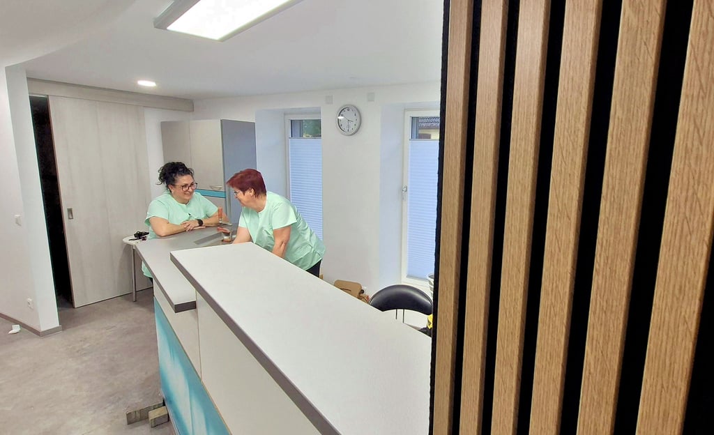 Die Gäste werden ab heute in der neuen Praxis in Empfang genommen. Akustikpaneele zieren eine Wand im Wartebereich. Der Tresen fügt sich als optische Verlängerung dieser ein. Zwei Wochen war wegen des Umzugs geschlossen.