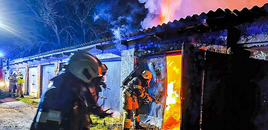 Einsatzkräfte der Feuerwehr Oschersleben kämpfen in der Neindorfer Straße gegen das Feuer in einer Garage.