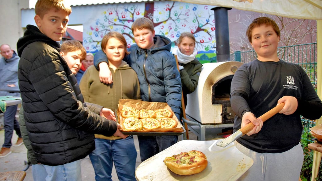 Pepe (von links), Mick, Louis, Marvin, Ronja und Joel aus der Klasse 7a holen beim Winterzauber frisch gebackene Köstlichkeiten aus dem schuleigenen Backofen.