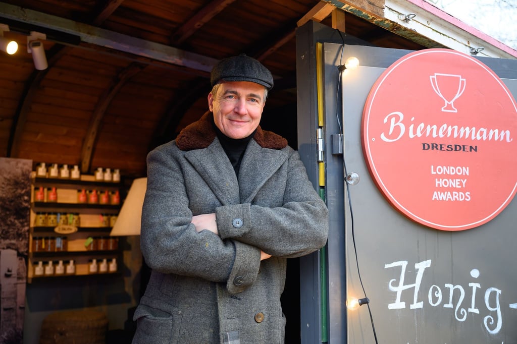 Imker Rico Heinzig an seinem Stand auf dem historischen Weihnachtsmarkt auf dem Neumarkt in Dresden.