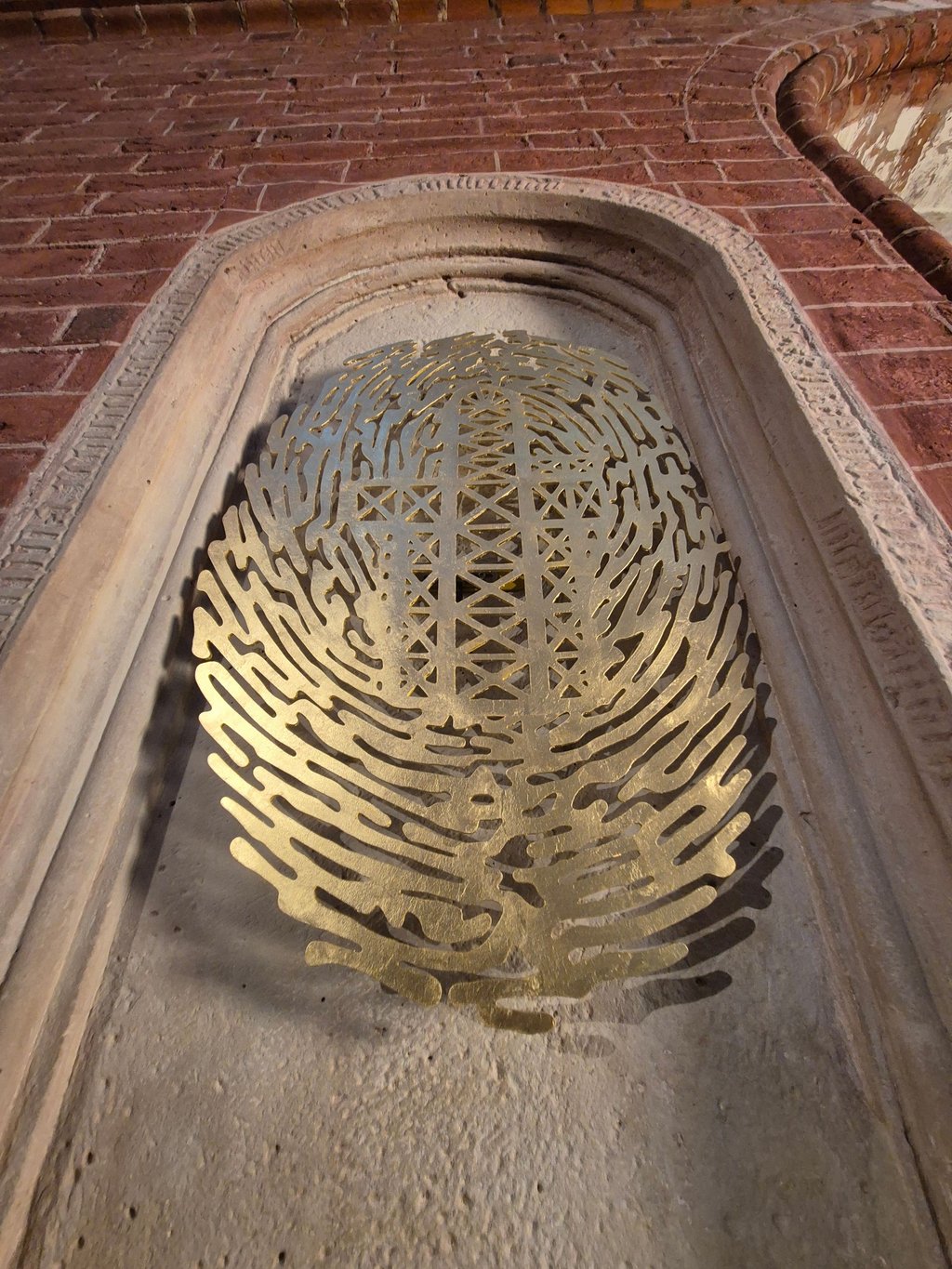 Das Nischen-Epitaph des Dietrich von Angern im Stendaler Dom. In der Mitte fügt sich der Umriss des Gotteshauses wie eine Prägung in eine Form ein, die einem Gehirn ähnelt.