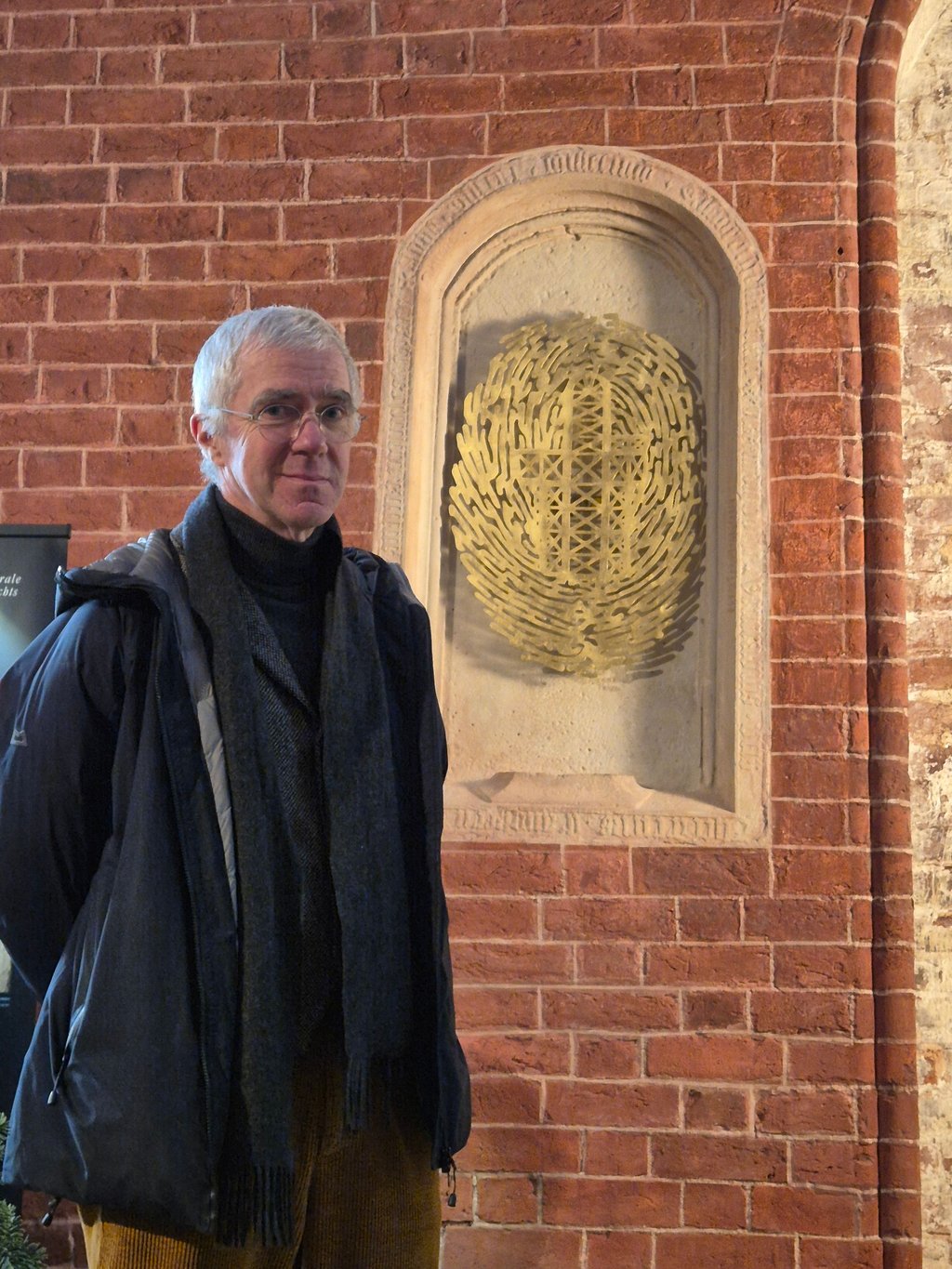 Künstler Thomas Leu aus Halle vor dem Nischen-Epitaph des Dietrich von Angern im Dom zu Stendal.