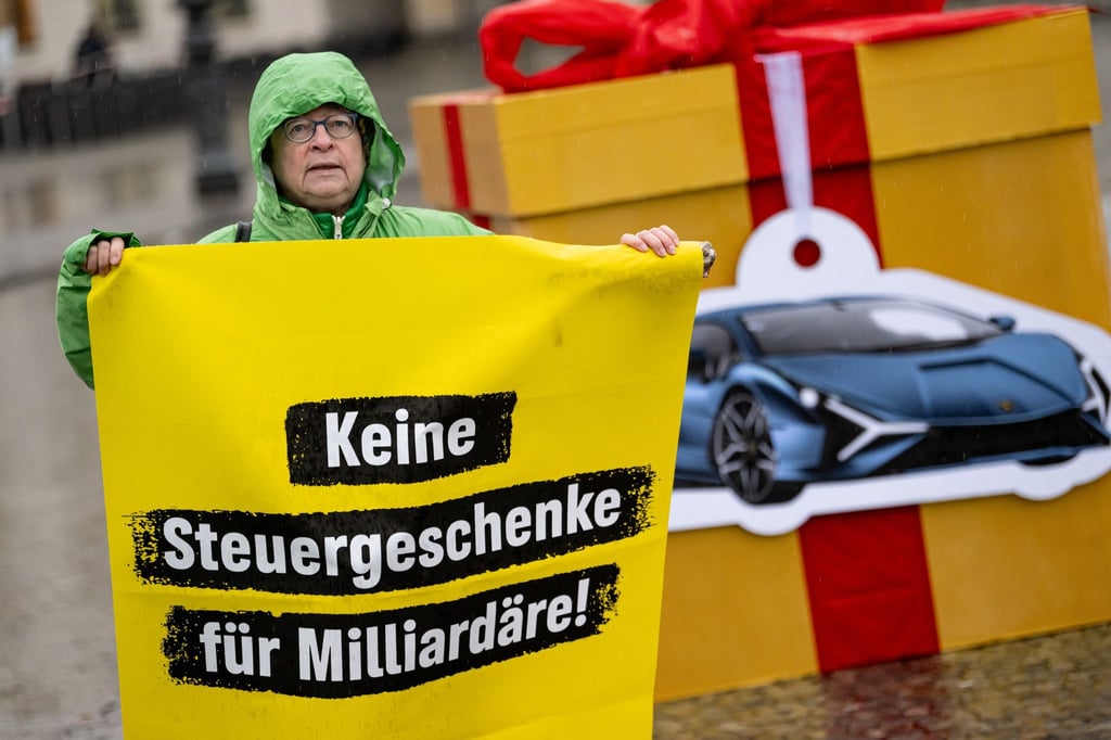 Eine Greenpeace-Aktivistin auf einem Protest für eine Milliardärssteuer am Brandenburger Tor.