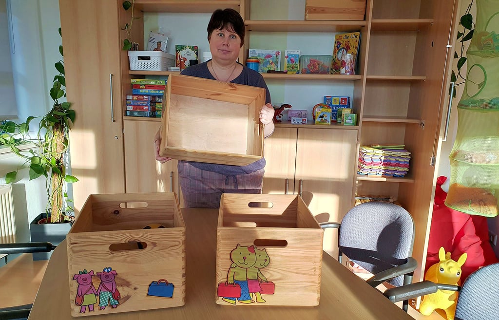 Jana Schweizer zeigt eine der leeren Kisten, die sich über Spenden wieder mit Spielzeug füllen sollen.
