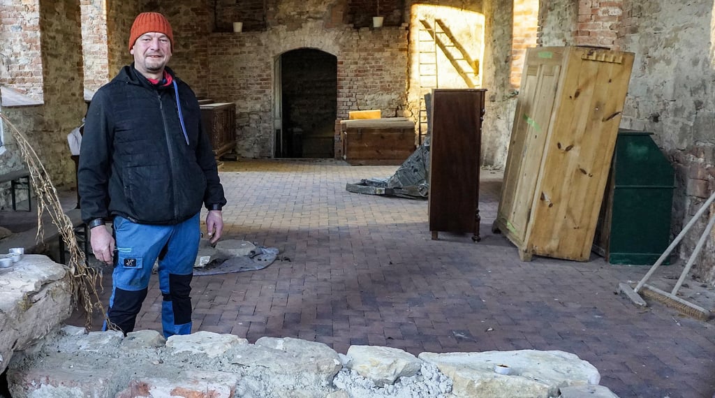 Christian Paul in der von ihm wiederaufgebauten Kirche in Oberthau vor dem steinernen Altar, der um die tausend Jahre alt sein soll.
