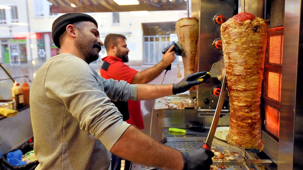 Ahmet Özkan und Bruder Imam schneiden Fleisch vom Spieß.