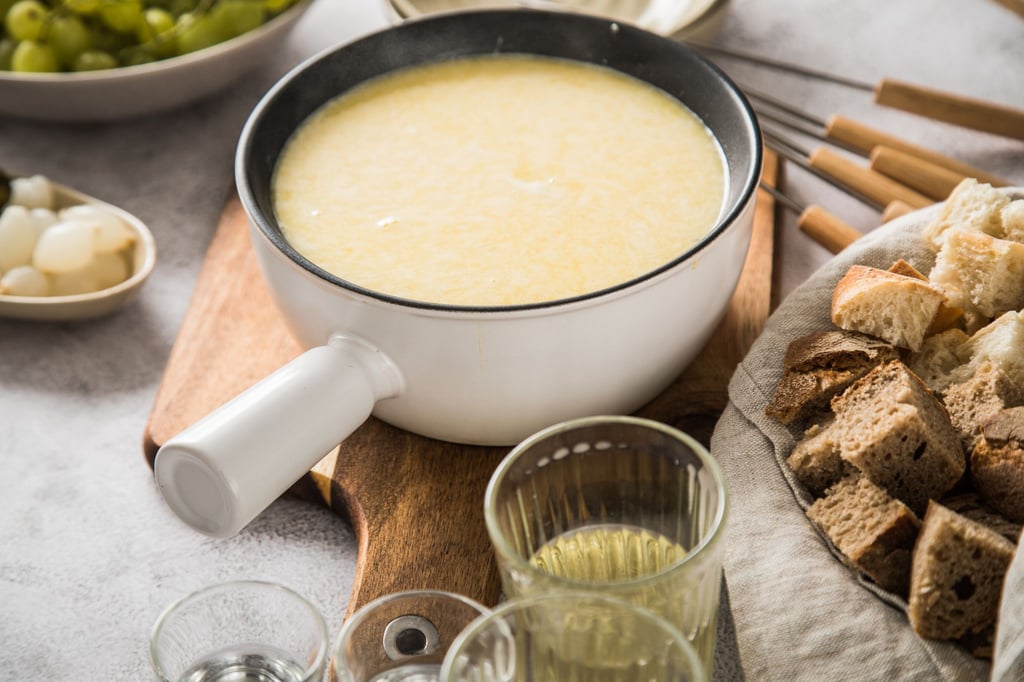 Klassischer Genuss: Das Schweizer Käsefondue Moitié-Moitié, serviert mit würzigem Brot, ist perfekt für gesellige Winterabende.