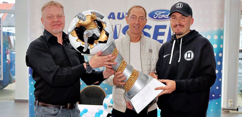 Autohaus-Geschäftsführer Stefan Herl, Turnierdirektor Ralph Hirsch und Nullfünf-Fußballer Felix Zilke (v.l.) mit dem Wanderpokal.