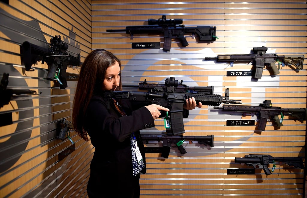 Eine Besucherin demonstriert auf der Messe Defence Security Equipment International (DSEI) in London ein Automatikgewehr. (Archivbild)