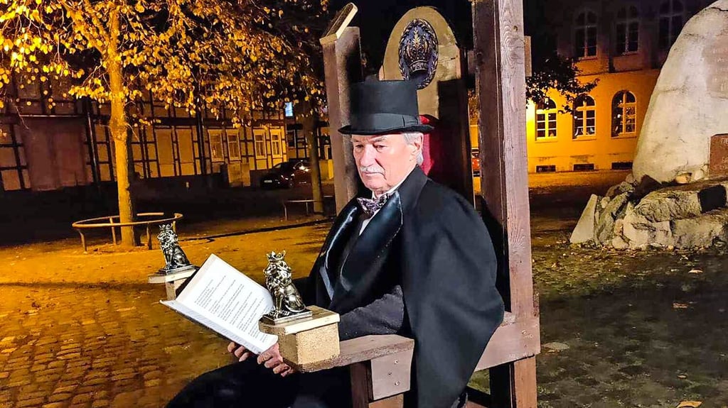 Manfred Freyhold sitzt auf einem Holzstuhl, den Bernd Fritzsche extra für den Video-Dreh gebaut hat.