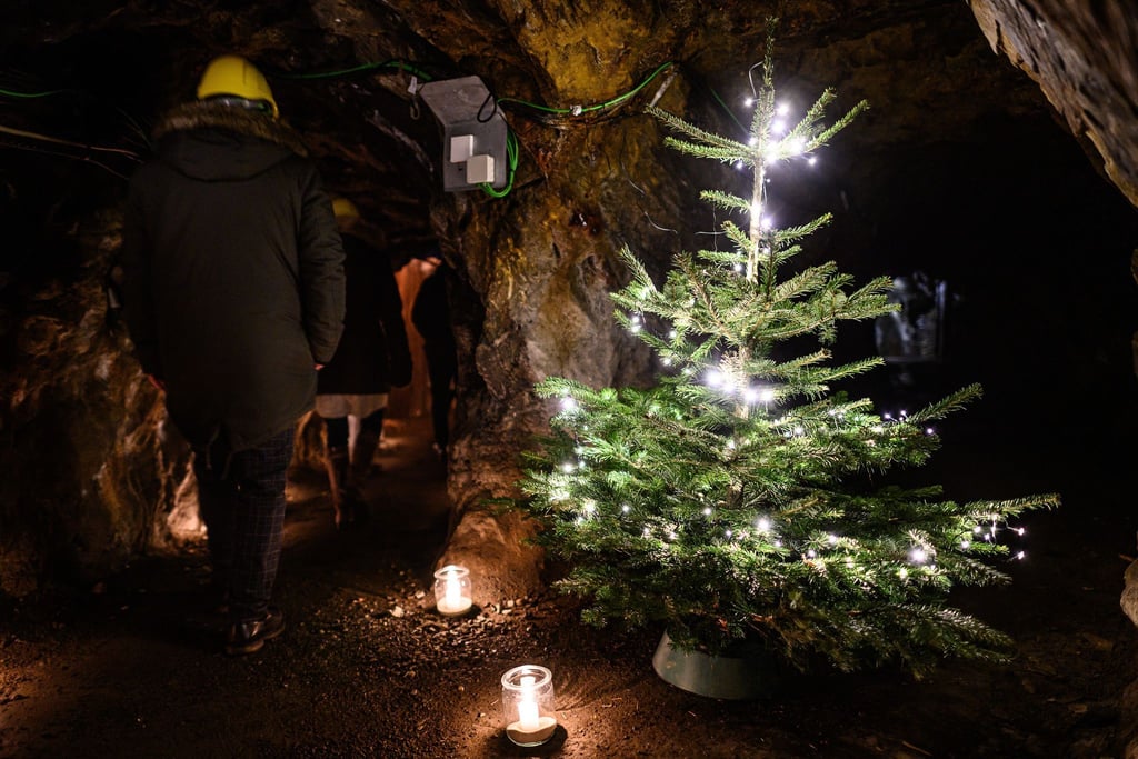Besucher gehen über den Weihnachtsmarkt unter Tage.