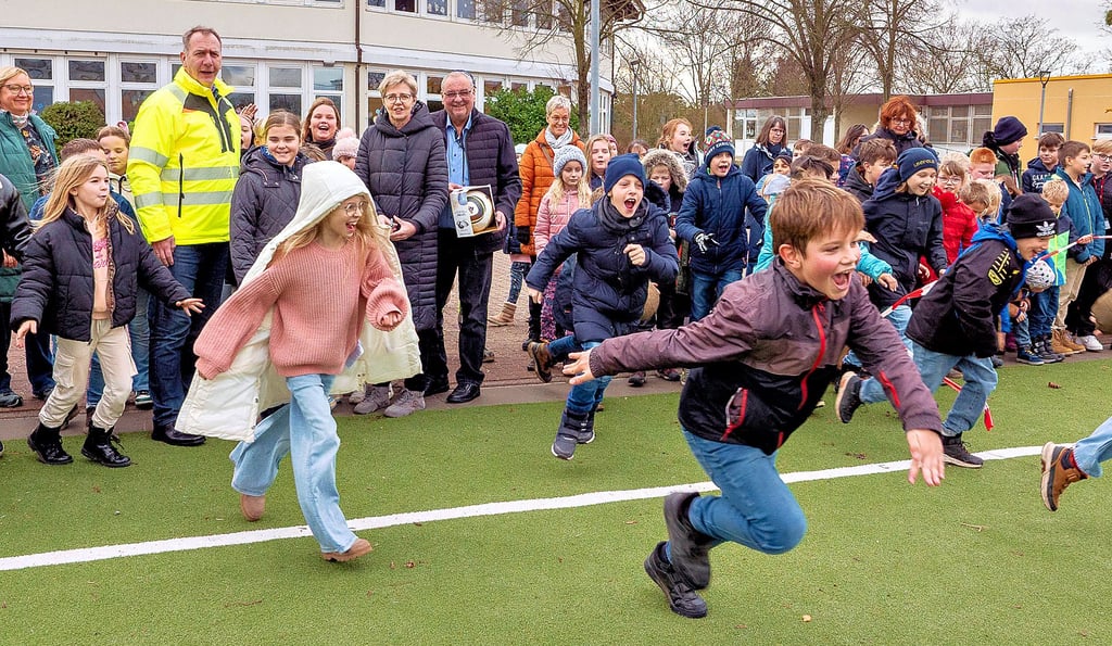 Da kann Gommerns Bürgermeister Jens Hünerbein (gelbe Weste) nur staunen. Nachdem er, Bauamtsleiterin Sylvia Tetzlaff und der Vorsitzende des Schulfördervereins der Grundschule Holger Busse das Band zur offiziellen Eröffnung des neuen Kunstrasenplatzes durchgeschnitten hatte, stürmten die knapp 380 Grundschulkinder den Platz regelrecht.