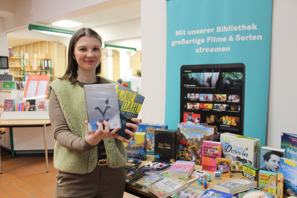 Bibliotheksleiterin Laura Zerneke zeigt Medien, die in diesem Jahr neu in die Bücherei eingezogen sind.