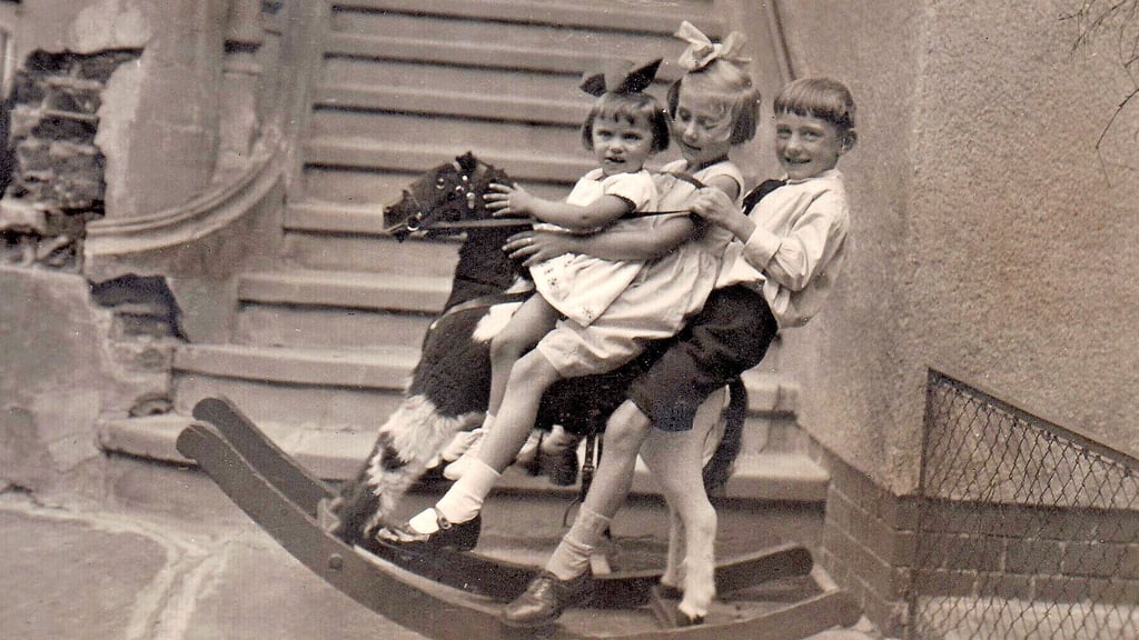 Hoch zu Ross wurden diese Kinder fotografiert, wenn auch nur auf dem Schaukelpferd, das aber immerhin Platz für die drei Kinder Annemarie Preiß und ihre mit im Haus Humboldtstraße 17 lebenden Spielfreunde Ilse und Hermann Wittwika bot. Das Foto entstand im September 1932.