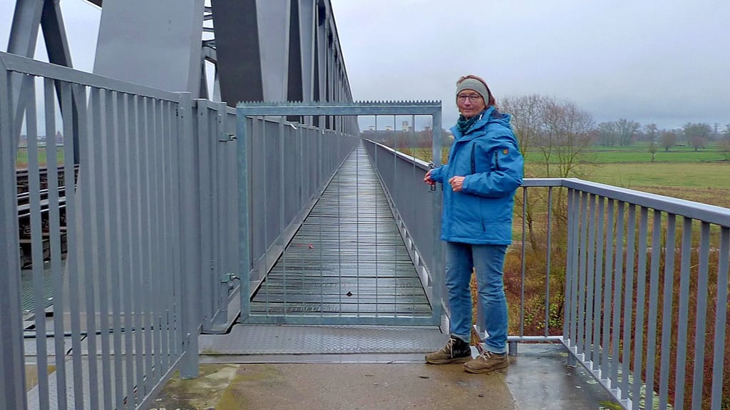 Susanne Bohlander steht auf Losenrade-Seite der Eisenbahnbrücke nach Wittenberge vor verschlossener Tür. Der Radweg ist seit Oktober 2024 gesperrt.
