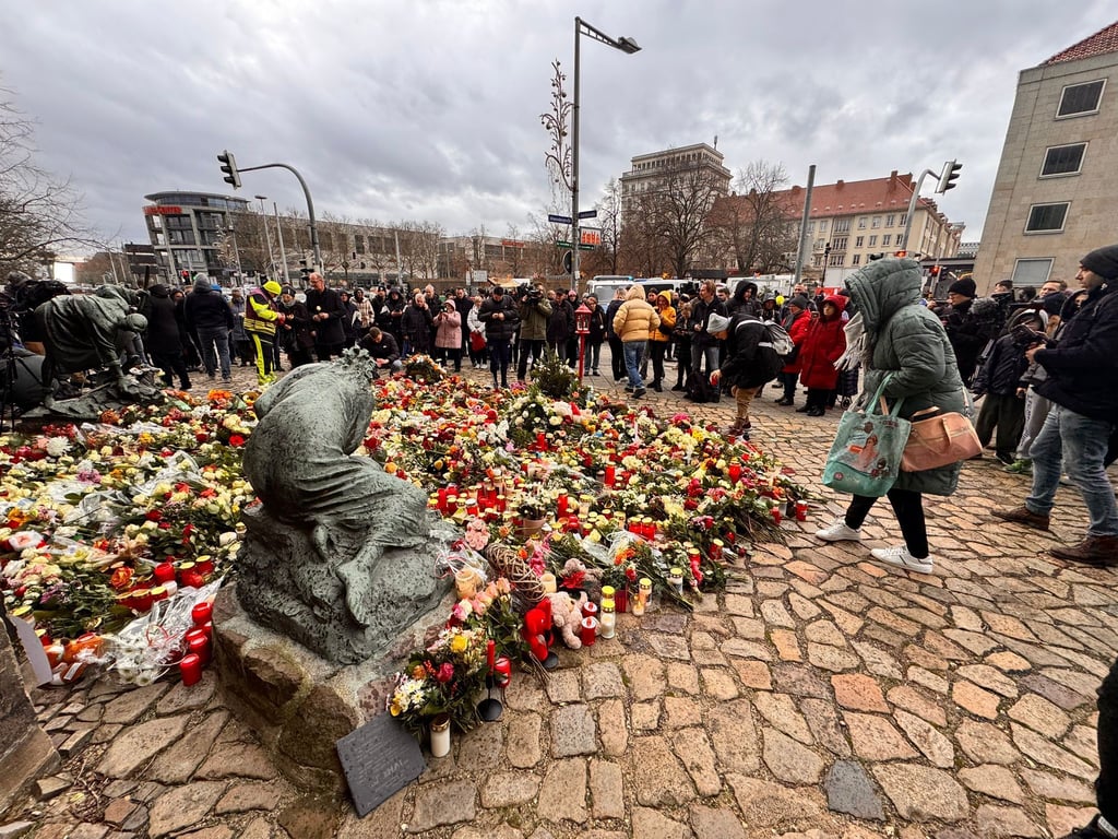 Vor der Johanniskirche in Magdeburg legen zahlreiche Menschen Blumen nieder.