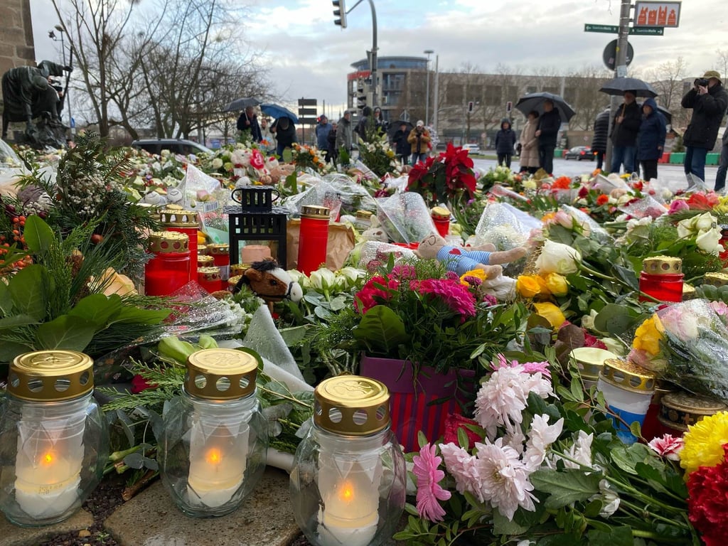 Auch noch zwei Tage nach dem Anschlag auf dem Weihnachtsmarkt legen Menschen zahlreiche Blumen und Kerzen vor die Johanniskirche in Magdeburg.