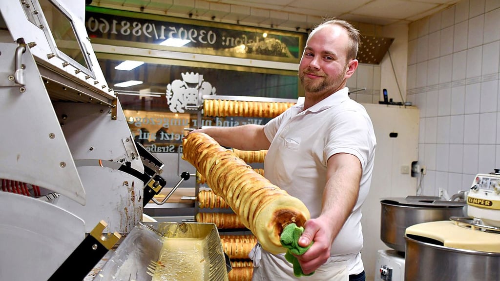 Konditorgeselle Oliver Körner zeigt, wie zehn Schichten beim Baumkuchenbacken aufgetragen werden. Eine Schicht wird etwa 20 Minuten gebacken. Dadurch ähneln die Schichten den Jahresringen eines Baumes.