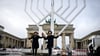 Rabbiner Yehuda Teichtal (l) und Rabbi Shmuel Segal tanzten bei der Einweihung des nach Veranstalterangaben größten Chanukka-Leuchters Europas auf dem Pariser Platz am Montag. (Archivbild)