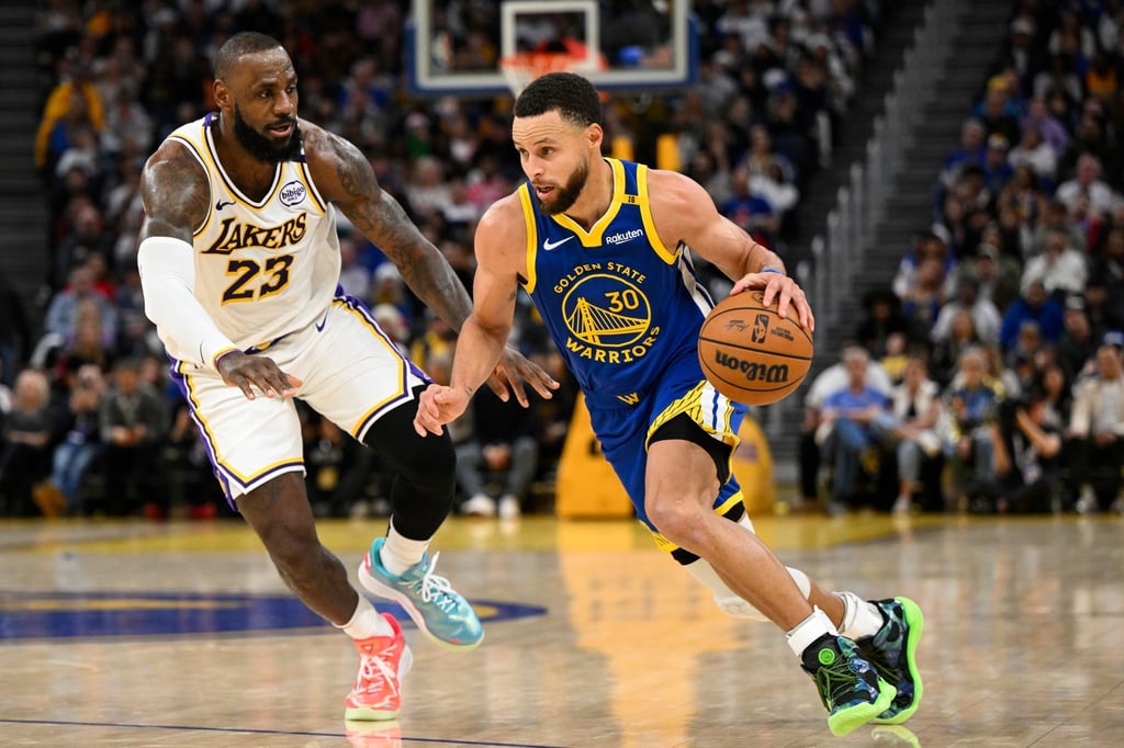 LeBron James (l) und die Los Angeles Lakers setzten sich bei den Golden State Warriors um Stephen Curry durch.